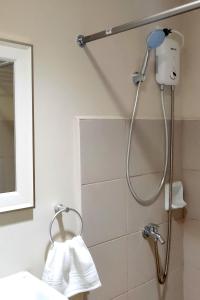 a shower in a bathroom with a towel at Sunvida Tower Stays Across SM City Cebu in Cebu City