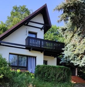 a house with a balcony on top of it at Domek na Porąbkach z kominkiem in Międzybrodzie Żywieckie