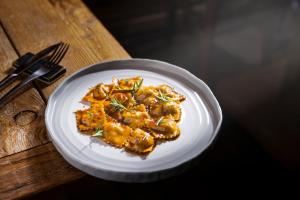 a white plate of food on a wooden table at Brieis Relais Alpino in Marmora