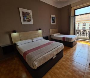 sypialnia z 2 łóżkami i dużym oknem w obiekcie Hostal Miami w Madrycie