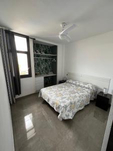 ein weißes Schlafzimmer mit einem Bett und einem Fenster in der Unterkunft Coconoa Beach in Playa del Ingles