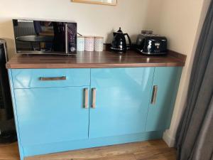 a blue cabinet with a microwave on top of it at The Count House in Saint Hilary +5 photos