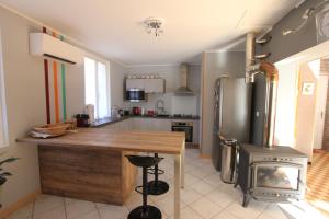 a kitchen with a stainless steel refrigerator and a stove at Maison au bord de l'eau avec Jacuzzi in Millau