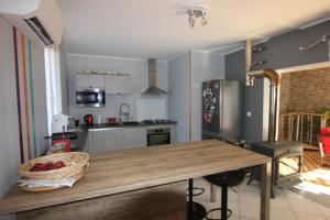 een keuken met een houten tafel in het midden bij Maison au bord de l'eau avec Jacuzzi in Millau +6 foto's