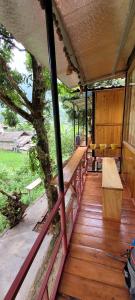 un porche de una casa con un banco y un árbol en Organic Farm Homestay en Sa Pa