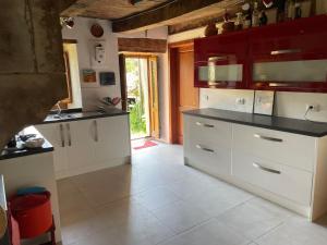 une cuisine avec des armoires blanches et des comptoirs noirs dans l'établissement Casa Della Luna, à Badia Tedalda 25 autres photos