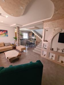 a living room with a green couch and a staircase at Villa le bonheur 