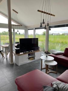 a living room with a flat screen tv on a cabinet at Ferienhaus G32 in Butjadingen