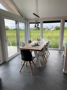a dining room with a table and chairs and windows at Ferienhaus G32 in Butjadingen