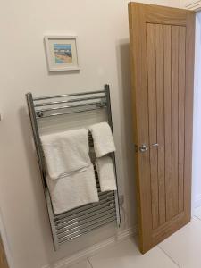 ein Handtuchhalter mit Handtüchern neben einer Tür in der Unterkunft The old forge 