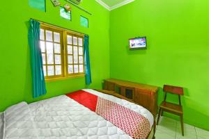 En eller flere senger på et rom på SPOT ON 91357 Hotel Mulyo