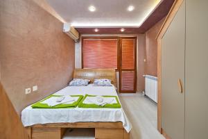 a bedroom with a bed with a green blanket at Apartment Knjaz Boris in Pomorie