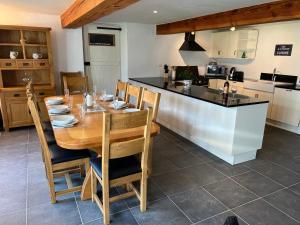 een keuken en eetkamer met een houten tafel met stoelen bij La Joie de Vivre in Bonnefont