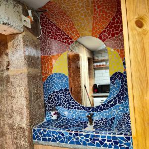 a bathroom with a mirror and a mosaic wall at Apartamento Ciudad Vieja Coruña in A Coruña
