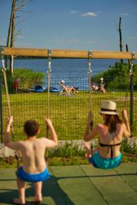 two people in bathing suits playing on swings at the beach at Lubaczówka in Iława