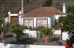 una piccola casa con piante in vaso davanti di Casa Rural Tio Pedro a Mazo
