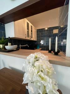een vaas gevuld met witte bloemen op een aanrecht bij Mango / Estudio con piscina!!! in Torrox Costa