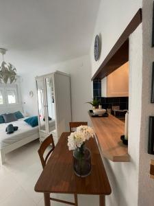 een woonkamer met een tafel en een slaapkamer bij Mango / Estudio con piscina!!! in Torrox Costa