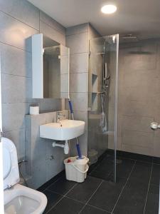 a bathroom with a sink and a shower and a toilet at Lovely Seaview Condo TII @ Jesselton Quay in Kota Kinabalu