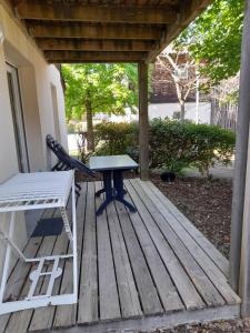 a picnic table and a bench on a deck at Appartement les Terrasses du Lac in Aureilhan