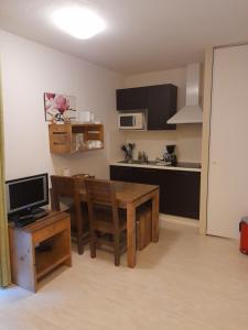 a kitchen with a table and a dining room at Appartement les Terrasses du Lac in Aureilhan