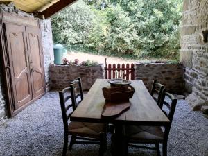 drewniany stół i krzesła na patio w obiekcie The Old Cider Press w mieście Carnoët