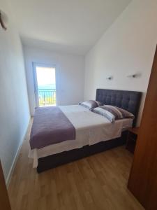 a bedroom with a large bed with a window at Apartments Jelica in Slatine