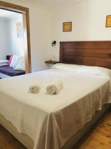 a large white bed with two towels on it at Casa Bernardita in Colunga