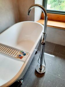 a sink with a faucet next to a bath tub at Longstone Bed & Breakfast in Challacombe