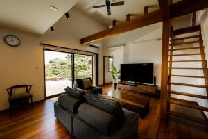 sala de estar con sofá y TV en 山里の家 en Nanjo