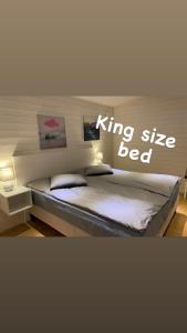 a bedroom with a king size bed with the words king size bed at Stuga in Myggenäs