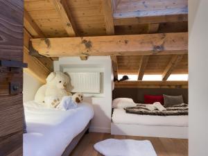 deux lits dans une chambre avec plafonds en bois dans l'établissement Appartement Contemporain avec Sauna, Cheminée et Parking au Centre de Courchevel 1850 - FR-1-564-35, à Courchevel