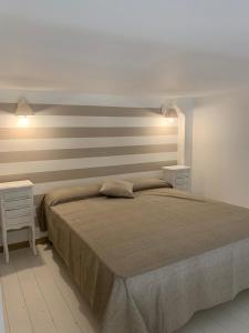 1 dormitorio con 1 cama grande y 2 mesitas de noche en Denise Vacanze - Monolocali arredati, en Bagheria