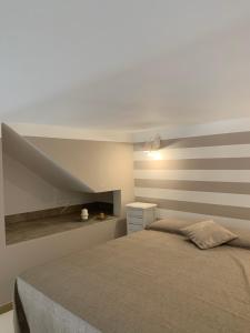 um quarto com uma cama com uma parede listrada em Denise Vacanze - Monolocali arredati em Bagheria