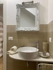 uma casa de banho com um lavatório e um espelho na parede em Denise Vacanze - Monolocali arredati em Bagheria