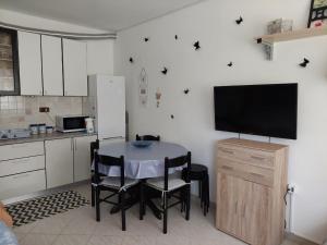 a kitchen with a table with chairs and a tv at Apartma Lavanda Istriana in Pobegi