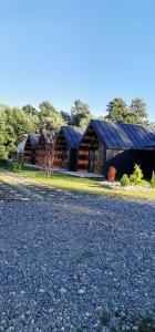 uma casa com um telhado preto no lado de uma estrada em Pastravaria Zavoi em Valea Danului