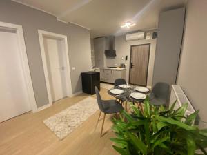a living room with a table and chairs and a kitchen at EM03- Apartament 2 camere luxury in Târgu Jiu