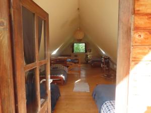 a living room with a staircase and a room with a ladder at Babou Maramures in Breb