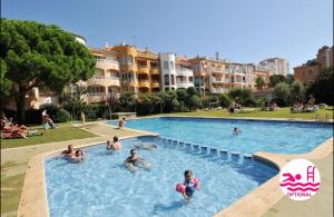 um grupo de pessoas a nadar numa piscina em Appartement 1 chambre climatisé avec 3 piscines à 200 m de la plage em Empuriabrava