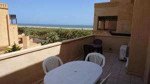 a balcony with a table and chairs and the beach at JARDINES DE ISLA CANELA By SIT ISLA CANELA -REF 171- in Isla Canela