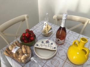 - une table avec une bouteille de vin et un bol de fruits dans l'établissement Borgo San Giovanni Luxury, à Francavilla Fontana