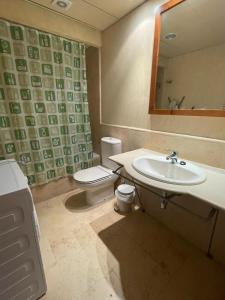 a bathroom with a sink and a toilet and a mirror at JARDINES DE ISLA CANELA By SIT ISLA CANELA -REF 171- in Isla Canela +6 photos