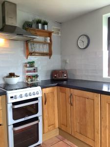 a kitchen with a stove and a clock on the wall at Mullaghmeen Forest in Mullingar