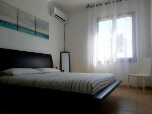 een slaapkamer met een groot bed en een raam bij L'appartamento sul borgo in Santa Lucia
