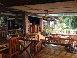 an empty restaurant with wooden tables and chairs at Hi coral cove bungalow in Chaweng Noi Beach