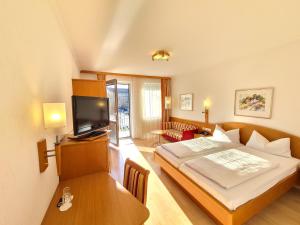 a hotel room with a bed and a television at Thermenhotel Tannenhof - Ihr Wohlfühl-Hotel in Bad Füssing
