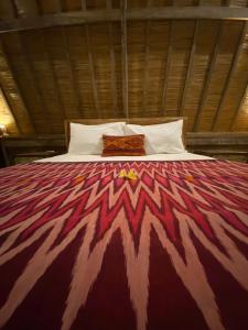 a bedroom with a bed with a colorful comforter at The Hideaway Canggu in Canggu