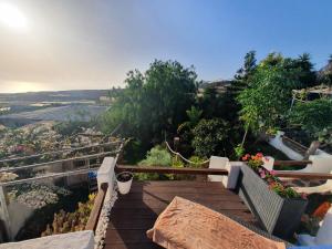 una escalera de madera con bancos y flores en una colina en Casa de Campo Lomo del Balo en Guía de Isora