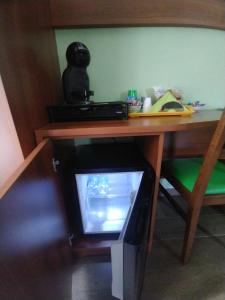 a television sitting under a desk with a wooden table at B&B IL GHIRO in Roccaraso